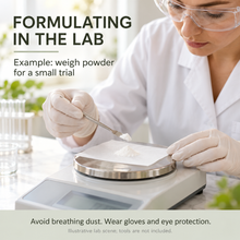 Load image into Gallery viewer, A woman in a white lab coat and safety goggles weighs a small amount of white powder on a digital scale in a lab setting, with text reading 'FORMULATING IN THE LAB' and 'Example: weigh powder for a small trial'.
